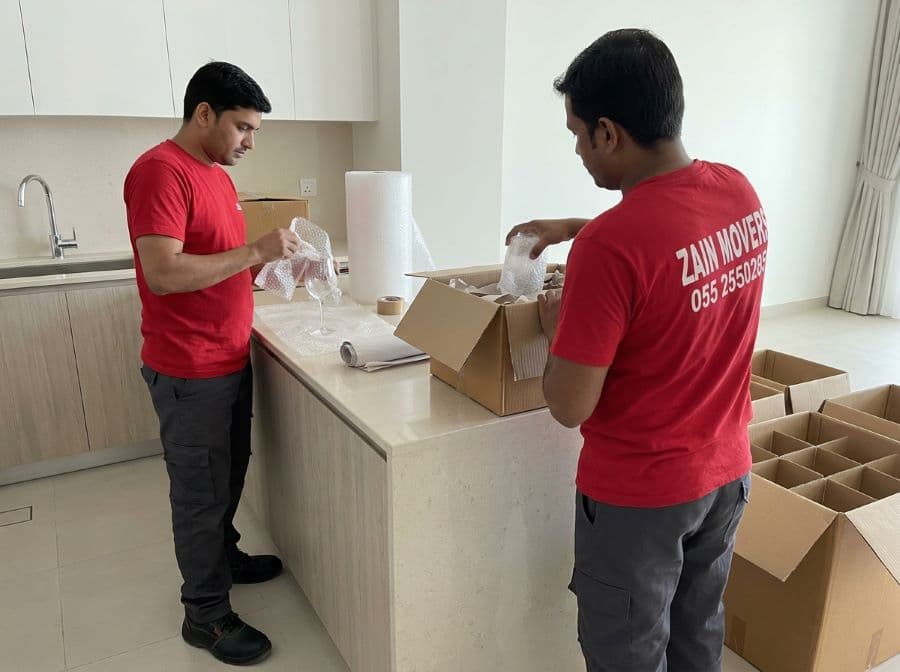 Zain Movers packers wrapping glassware in bubble wrap before boxing in a Dubai home