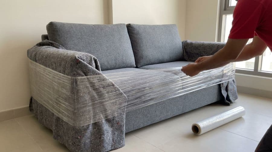 Heavy-duty blankets and stretch film applied to a sofa in JVC