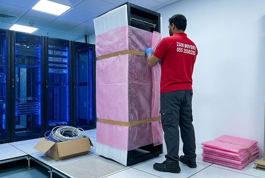 Anti-static packing being applied to a server rack before transport by Zain Movers in Dubai