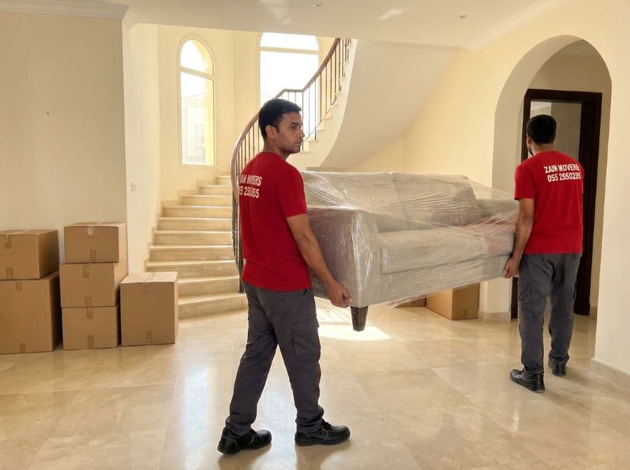 Zain Movers crew carrying a sofa through a Dubai villa living room