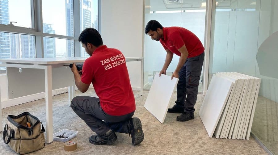 Modular office desks being dismantled by carpenters in Business Bay