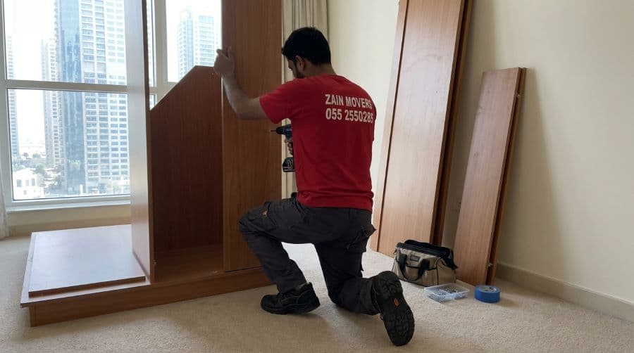 Carpenter dismantling a wardrobe inside a Dubai Marina apartment