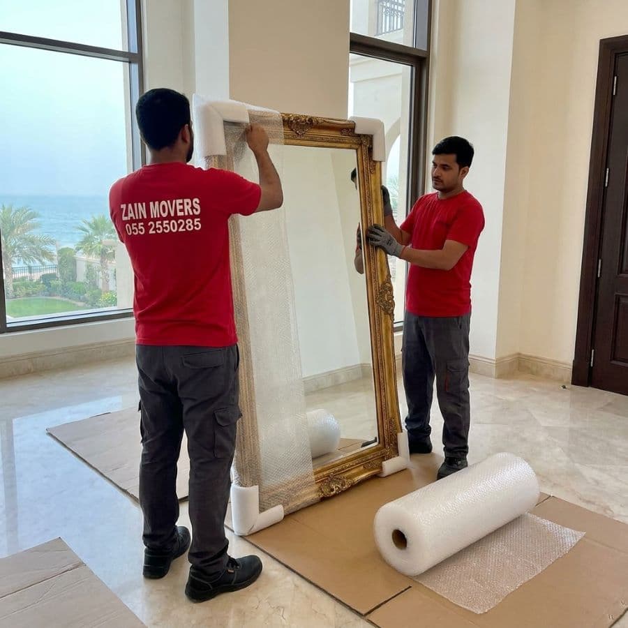 Zain Movers crew wrapping a mirror inside a Palm Jumeirah villa